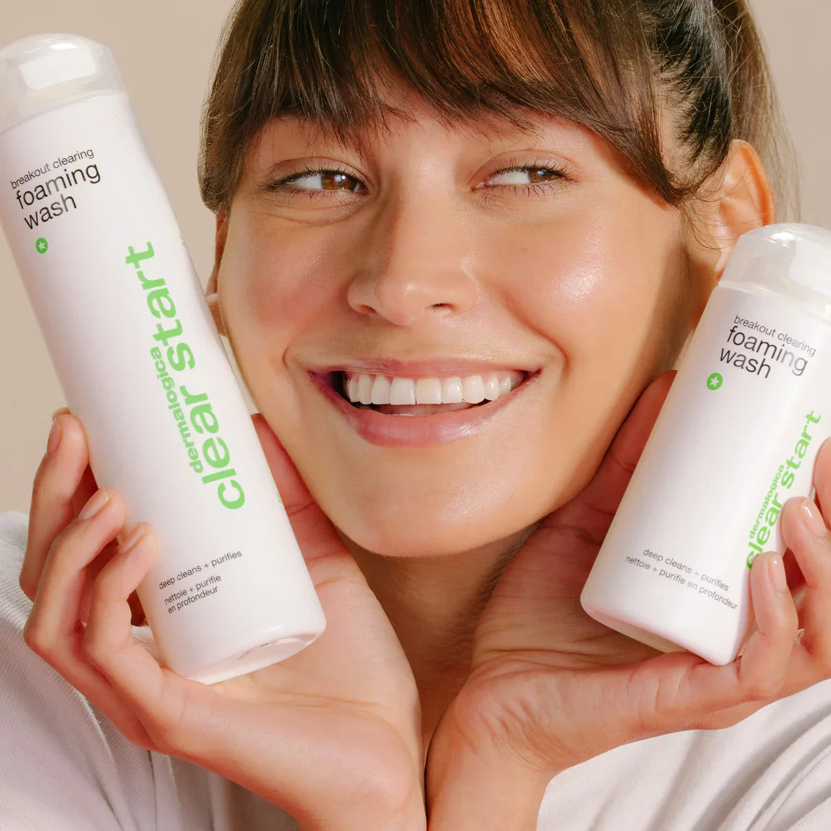 Model holding both sizes of Dermalogica Clear Start Breakout Clearing Foaming Wash